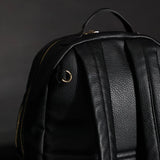 The back of the Changing Backpack showing where the stroller clips attach to and the grab handle.