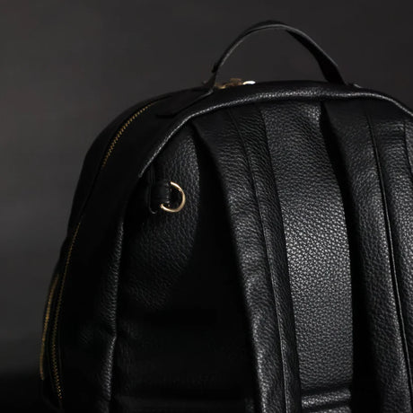 The back of the Changing Backpack showing where the stroller clips attach to and the grab handle.