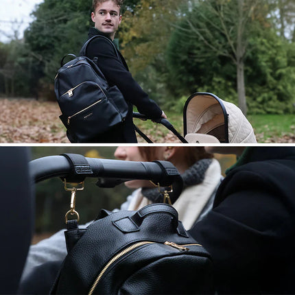 Man pushing a stroller with a black backpack, surrounded by greenery with a close up of the backpack hanging on the back of a stroller using stroller clips.