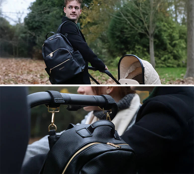 Man pushing a stroller with a black backpack, surrounded by greenery with a close up of the backpack hanging on the back of a stroller using stroller clips.