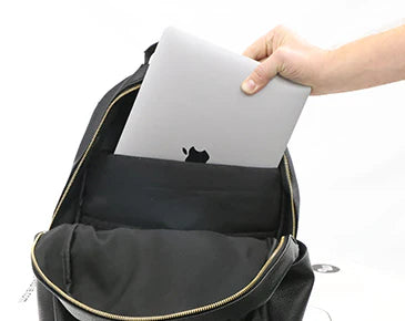 Person placing a laptop into a black changing backpack.